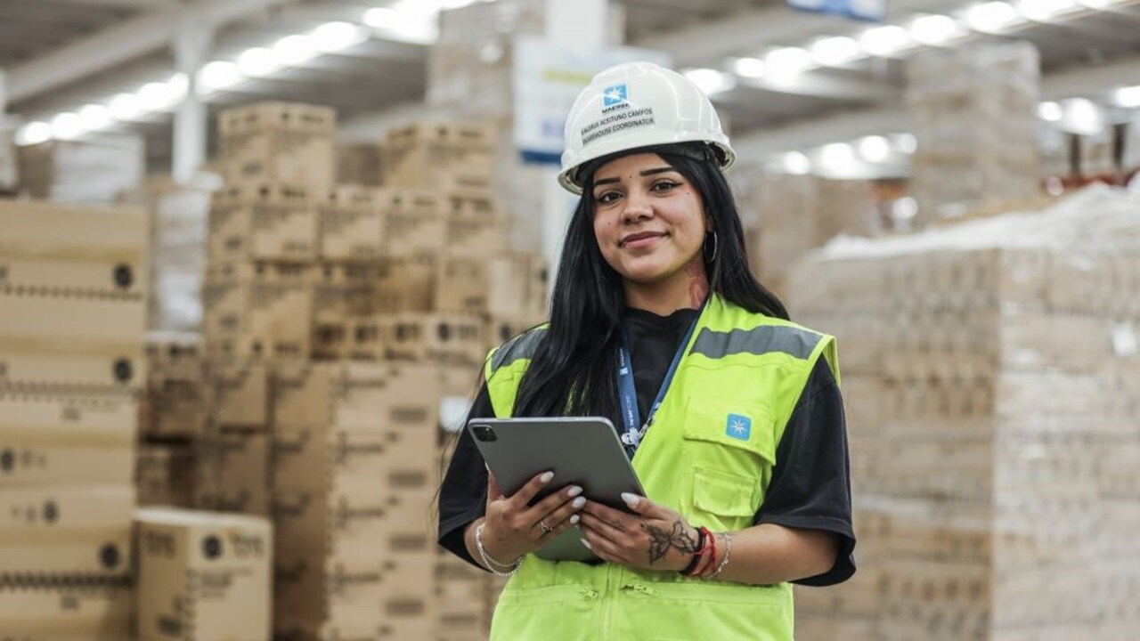 Woman in safety gear in warehouse.