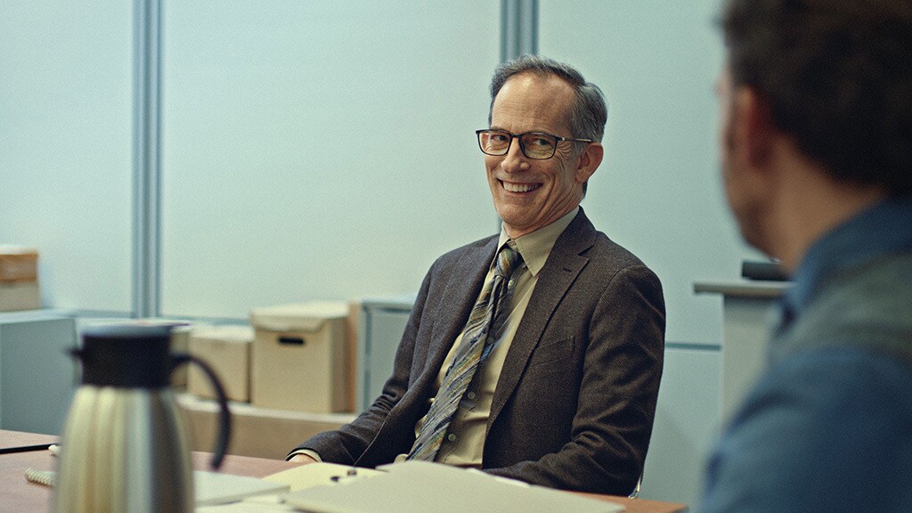 Smiling businessman in a suit and glasses during an office meeting, symbolizing trust and reliability in professional services