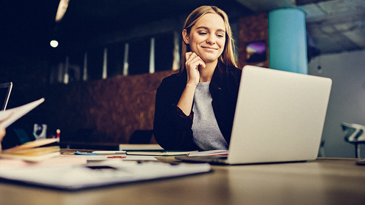  The employee is focused on work, using their laptop to boost productivity.