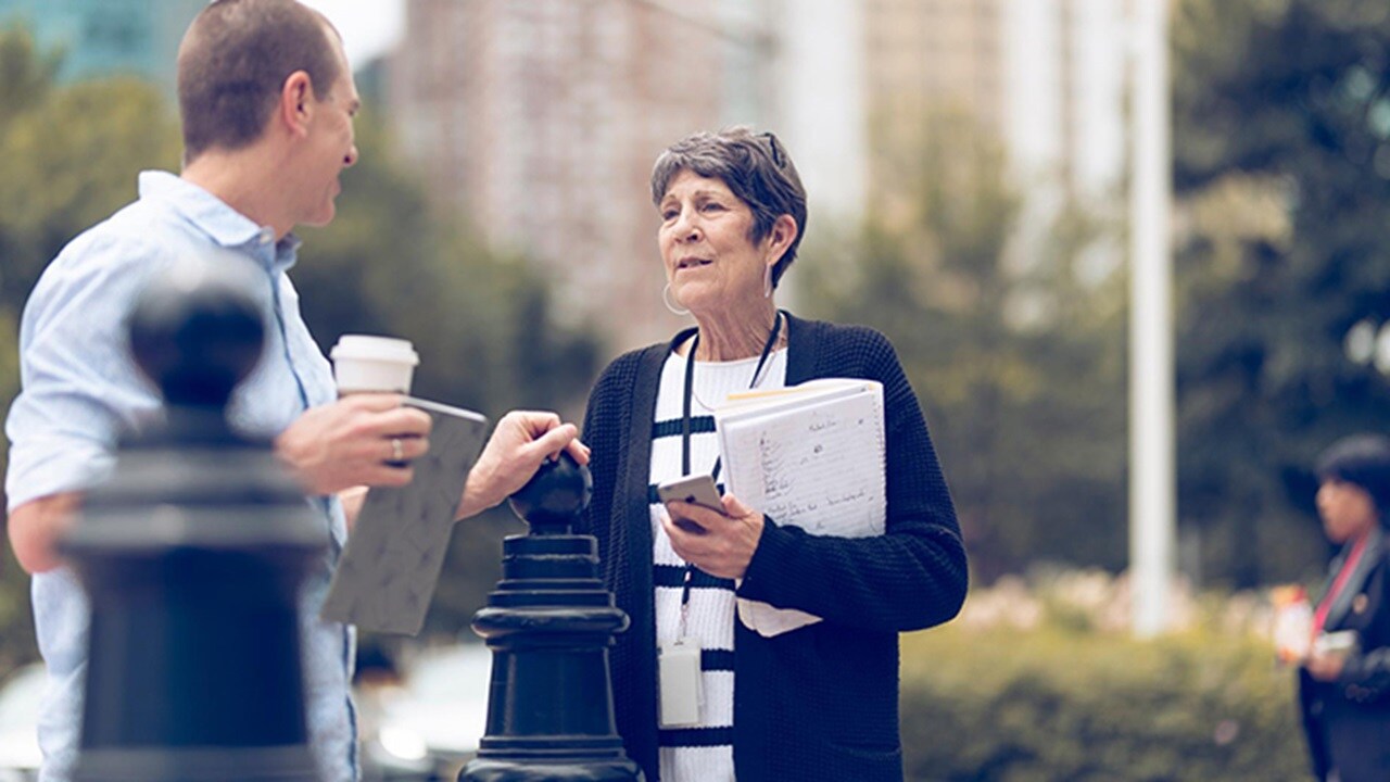  An elderly woman converses with a middle-aged man.