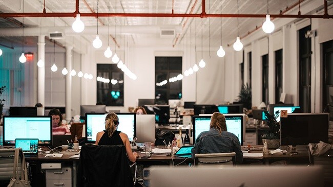 Office with people working at their computers working with digital customs.