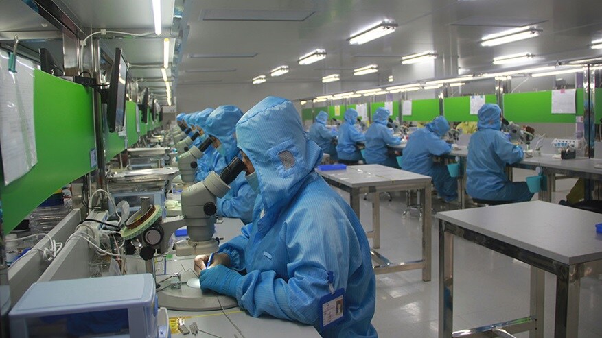 Medical professionals in safety suits working in a pharmaceutical laboratory