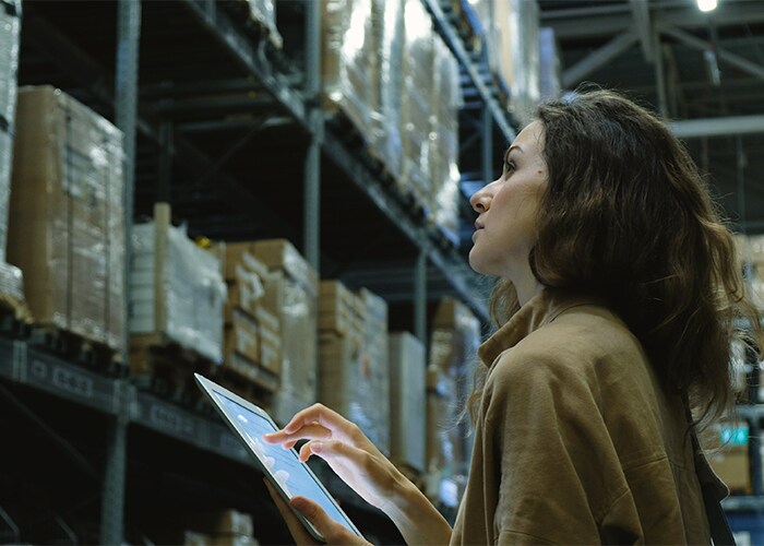 Female checking logs in a warehouse