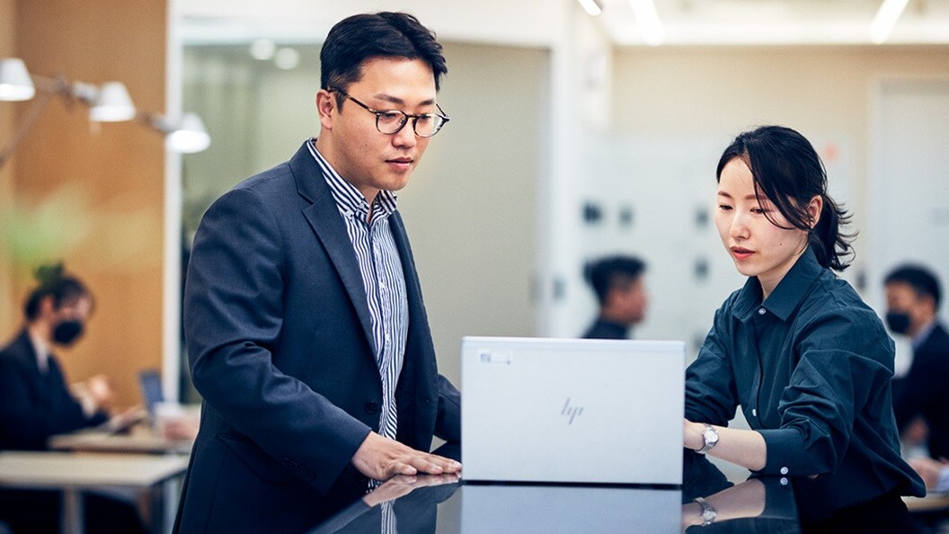 A man and a woman working at a personal computer to build supply chain resilience.