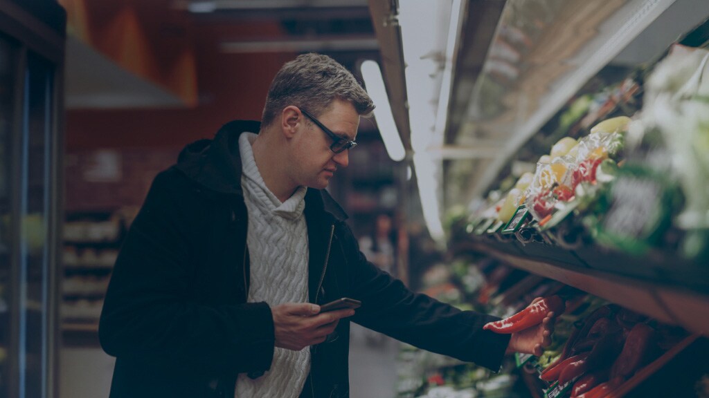 A male picking vegetables in a mart