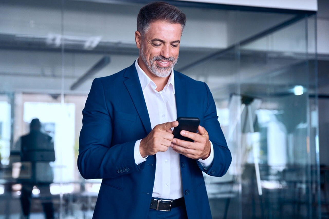 Male smiling while using his phone