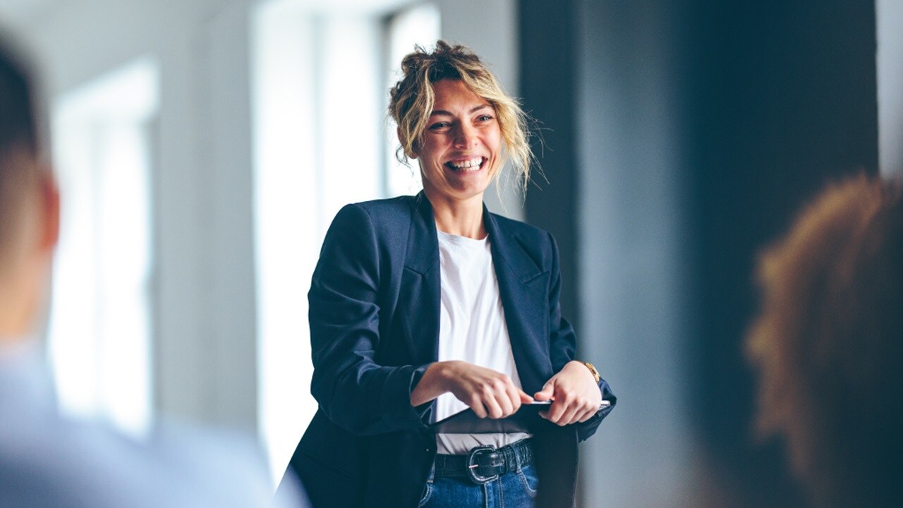 A smiling woman looking at the MyCustoms online platform on their mobile