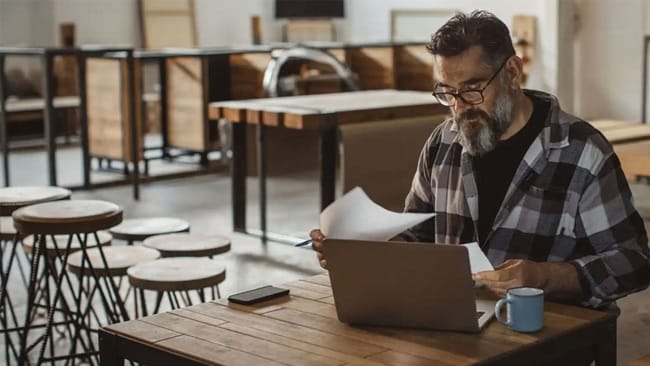 man sitting at a table doing paperwork