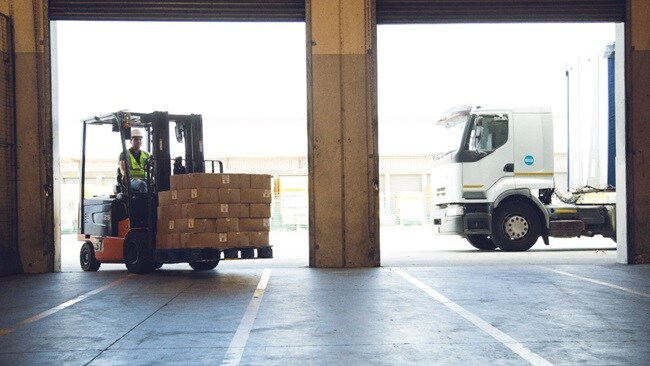 Forklift truck unloading a lorry into a food distribution warehouse