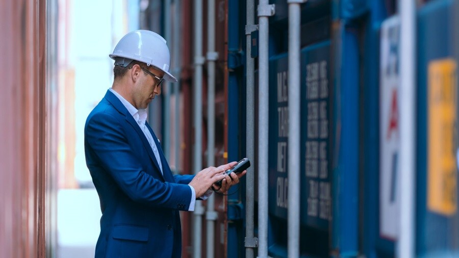 Male working on a tablet outside a container