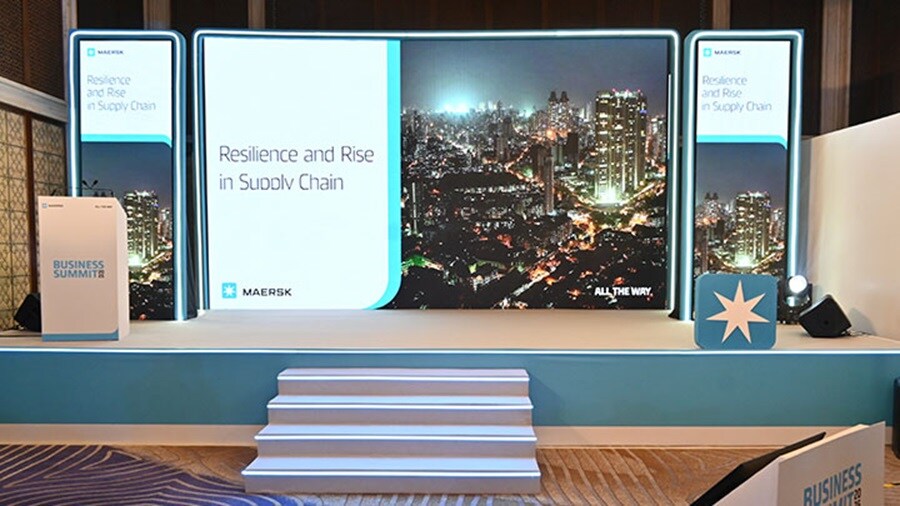 A stage featuring a large screen and a podium, set for a presentation or event.