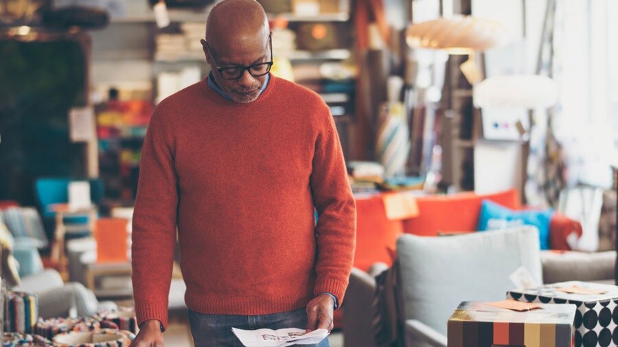 Male reading a paper and matching it with information on the tablet