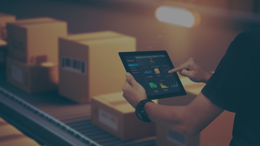 A set of hands holding a tablet with shipment in the background