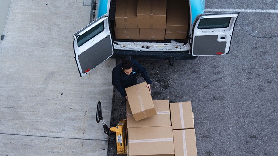 Delivery person loading parcels into Maersk last mile delivery van.