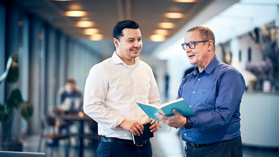 Two colleagues talking in the hallway