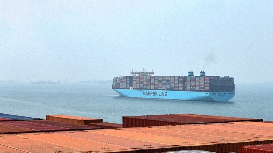 A large Maersk container ship navigates through calm waters, showcasing its colorful cargo containers stacked high