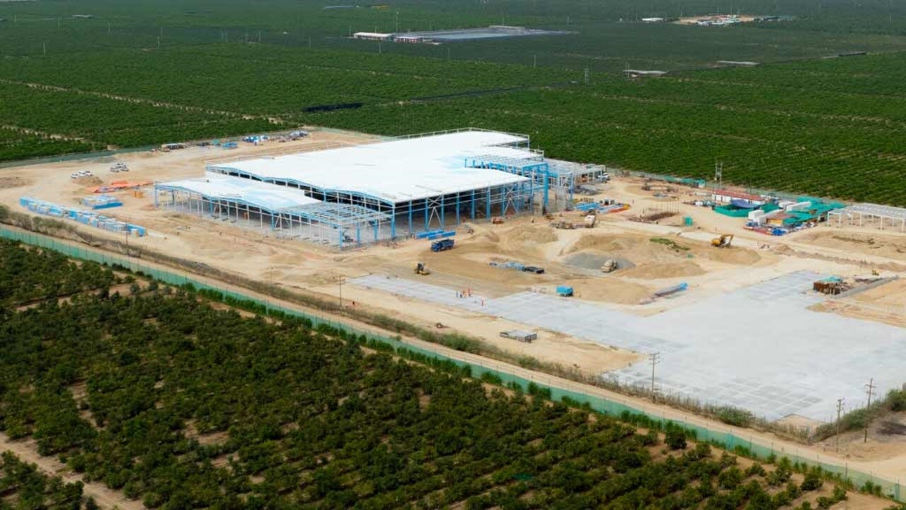 Aerial view of a large building under construction, showcasing scaffolding and machinery on the site.