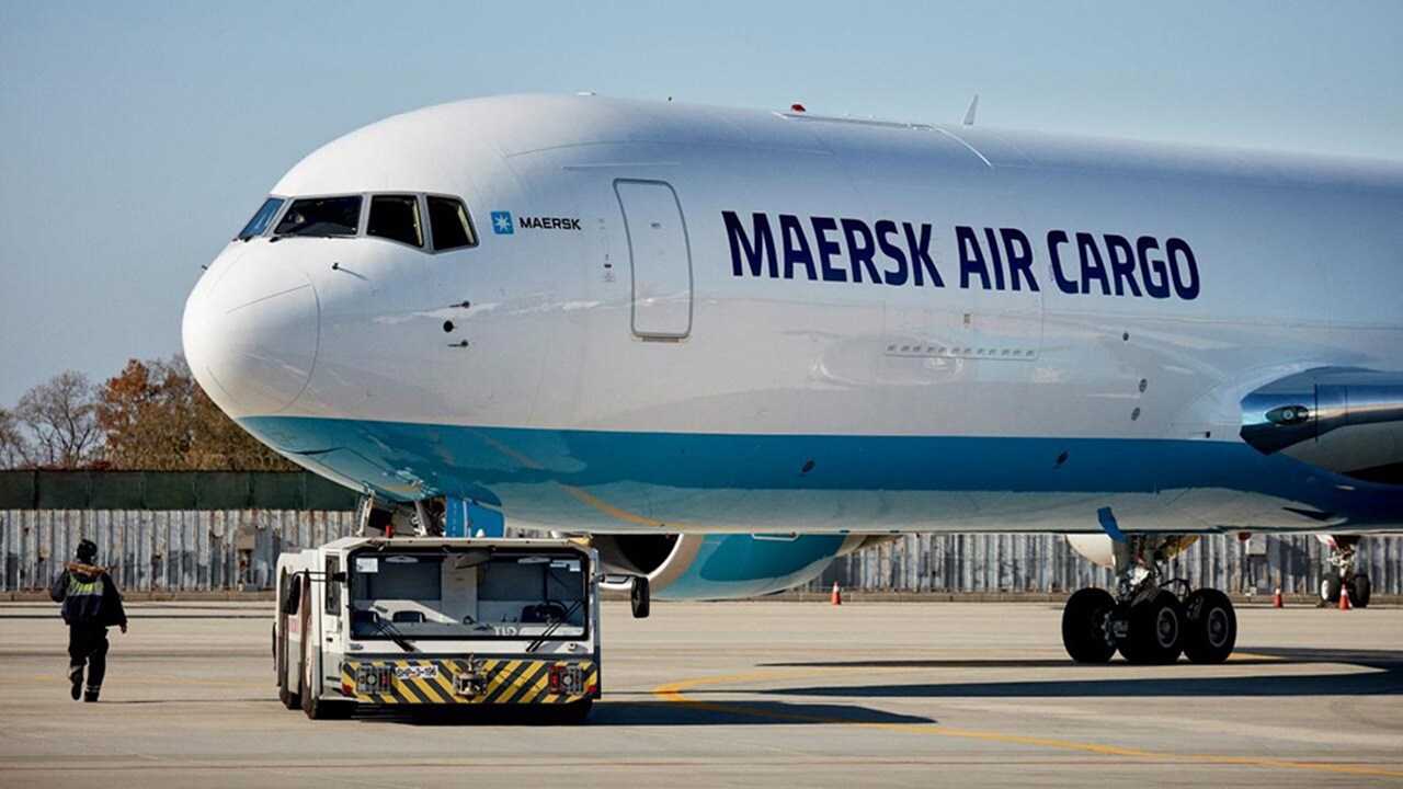 A Maersk Air Cargo aircraft on the tarmac being towed by a ground vehicle.