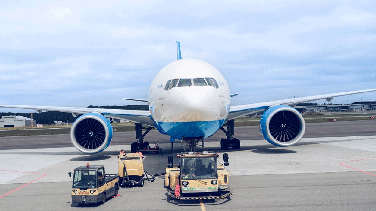 Airport cargo truck loading luggage and freight onto an airplane at the tarmac.