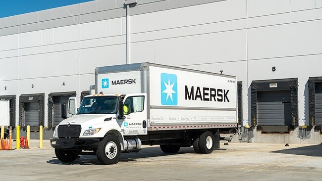Maersk truck parked at warehouse loading docks for cargo operations