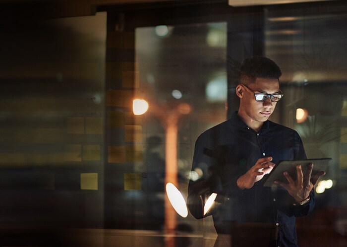 A young man using their tablet to explore API solutions.