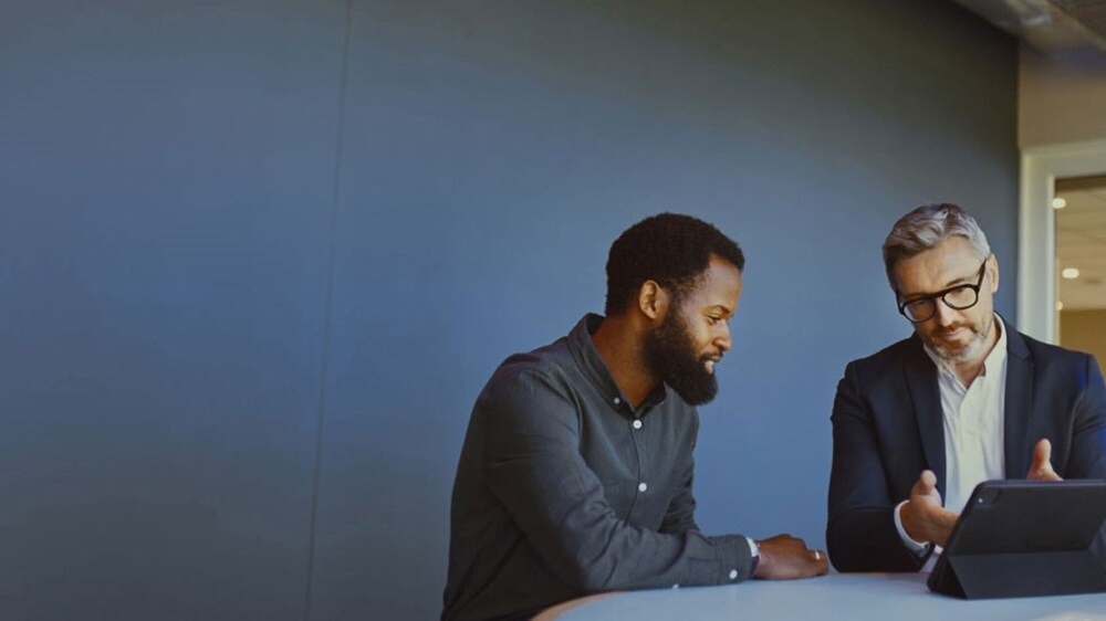 Due imprenditori discutono gli elementi essenziali dell'ECTN utilizzando un tablet.