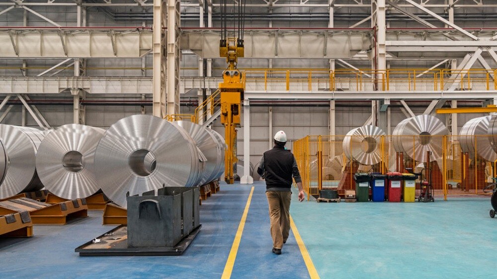 握手を交わすスーツを着た2人のビジネスマンと、背景の3人目の人物が合意やパートナーシップを象徴。