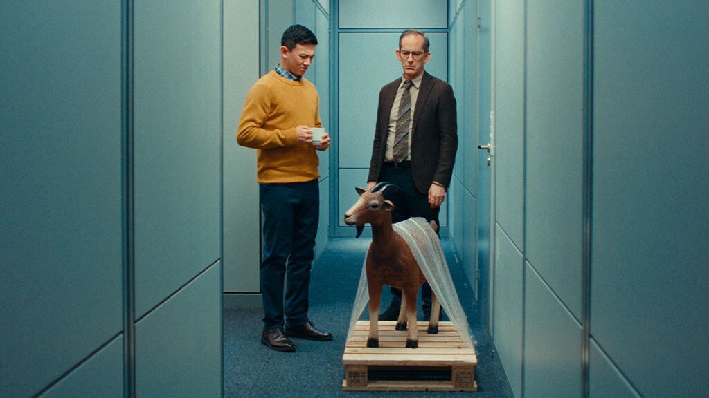 Two men with a goat delivered to their office.