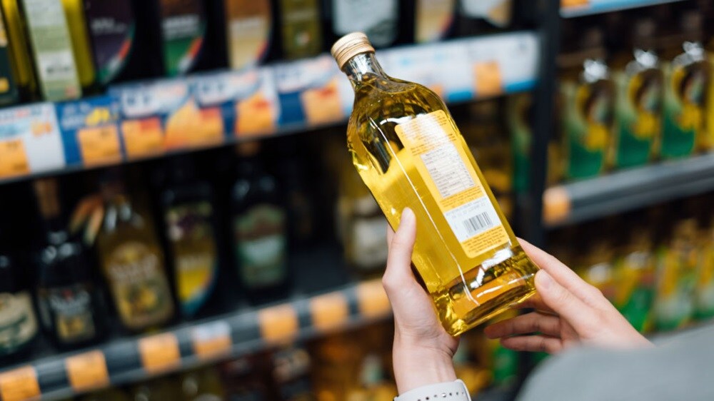 A set of hands holding vegetable oil bottle